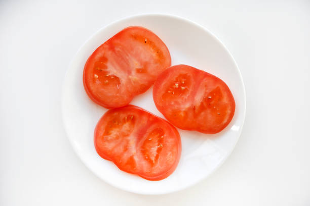 istock Chopped tomato on a white plate. Tomato salad. Sliced vegetables. Red tomatoes. 1492403191