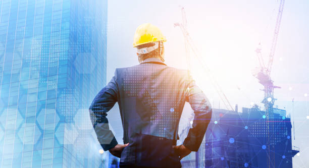 istock Businessman standing back during sunrise superimposed on cityscape.Architect construction, structure of tall buildings, architect and refinery industry concepts. 1492404767