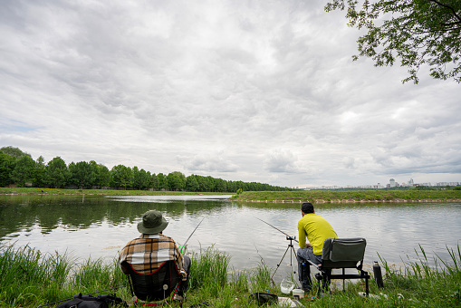 Two men are fishing at the city area