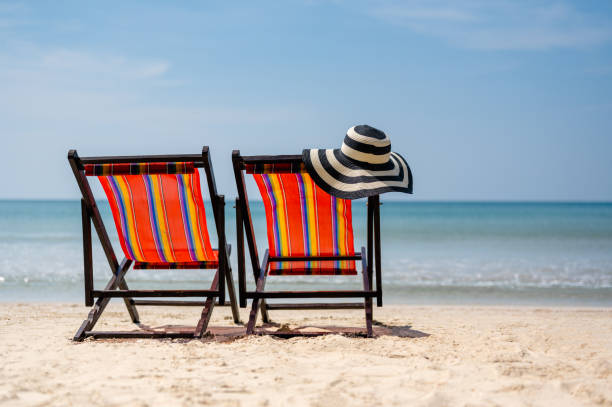 istock Blue and white striped beach hat, beach chair, two beach chairs on tropical sandy beach, summer travel, vacation and  summer holiday concepts. 1492405700