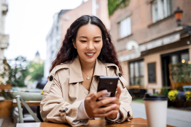 istock Asian young woman using phone in coffee shop 1492405906