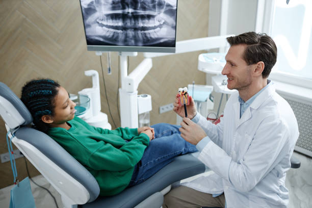 istock Dentist holding tooth model while consulting child 1492407299