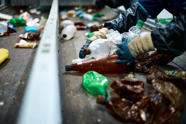 istock Worker sorts trash on conveyor belt at waste recycling plant 1492409048
