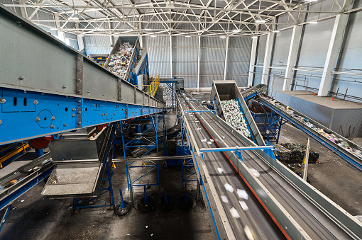 Conveyor belt transports sorted litter at recycling plant closeup. Technology of waste materials reusing. Sustainable production process
