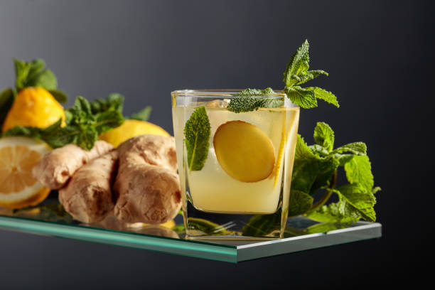 cocktail di birra ginger ale con limone e menta in un bicchiere ghiacciato su sfondo nero. - ginger tea root hot drink foto e immagini stock