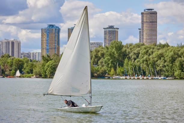 man on laser boat with sail on water