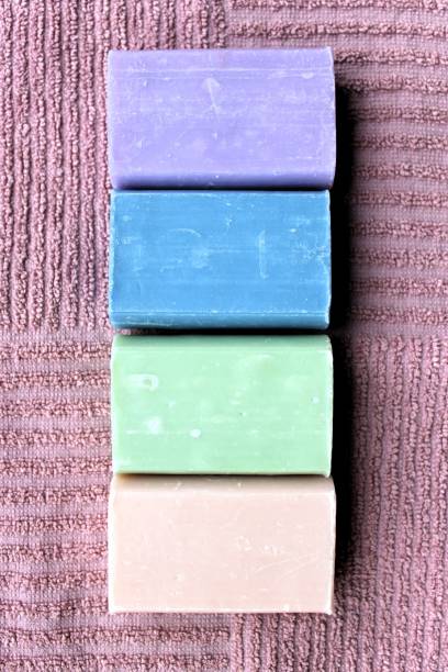 istock Handmade natural soaps with different scents: Blue is Pine, Green is Honeysuckle, Apricot is Jasmine and Purple is Violet. They lie on a towel. 1492413108