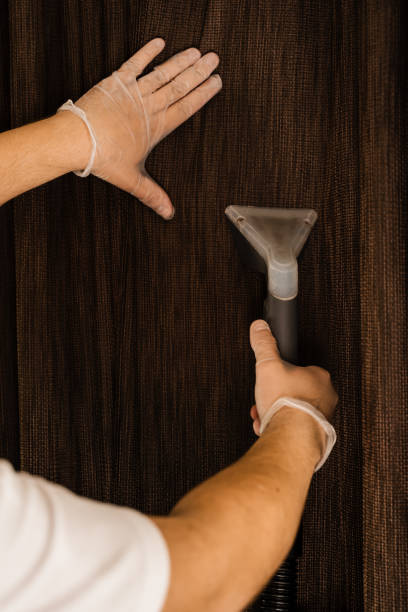 istock Process of extracting dirt and dust from curtains. Dry cleaning of curtains using extraction method in professional cleaning service. Cleaning curtains with extractor machine. 1492414469