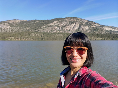 Selfie of a woman at Vaseux Lake located along the course of the Okanagan River in the Okanagan Valley of British Columbia, Canada.