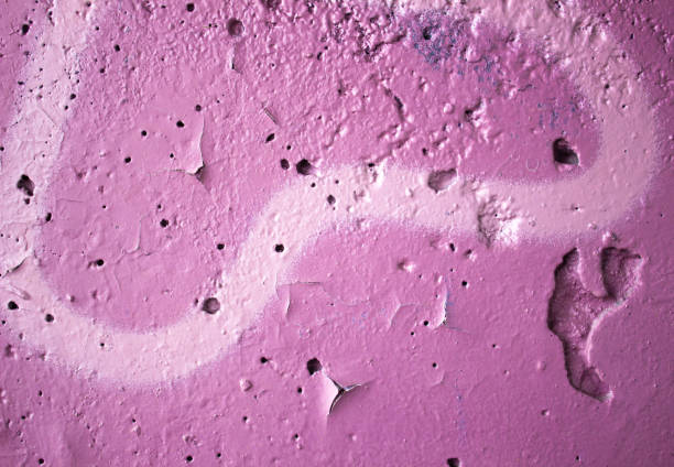 Directly above close-up view of cracked green asphalt painted with white color and a tire track mark on it