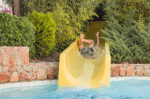 Man having a mishap during a water park slide ride
