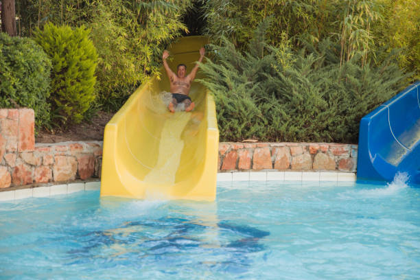 istock Cheerful man enjoying swimming pool slide 1492420819