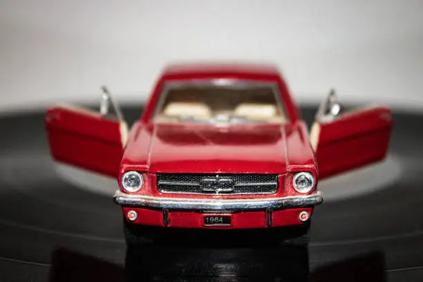 Photo of red mobile toy car on musical vinyl