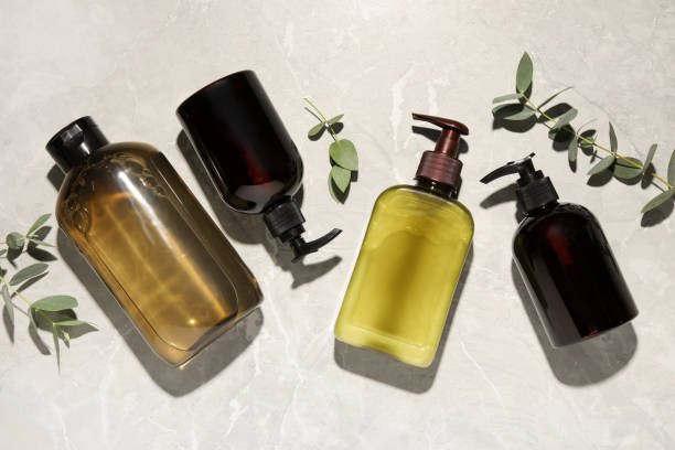 istock Shampoo bottles and leaves on white textured table, flat lay 1492422400