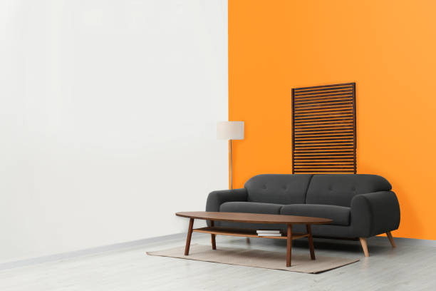 istock Stylish room with cosy sofa near orange wall. Interior design 1492422490