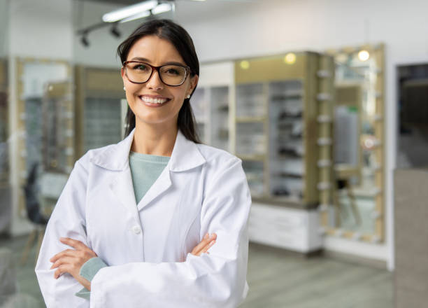 Happy ophthalmologist working at an optician store stock photo