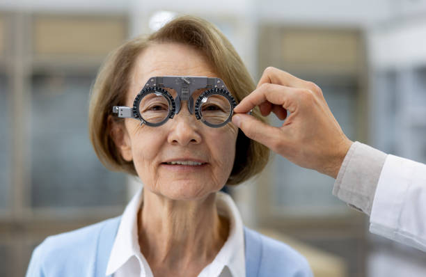 retrato de uma mulher idosa recebendo um exame oftalmológico no oftalmologista - patient senior adult optometrist eye exam - fotografias e filmes do acervo
