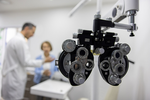 Patient in an eye exam with the optometrist - focus on the phoropter