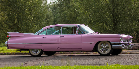 Stony Stratford, Bucks, UK Aug 29th 2021. 1959 PINK CADILLAC classic car travelling on an English country road