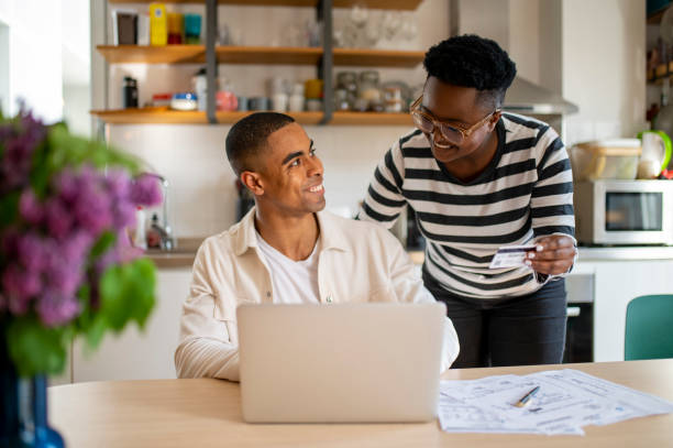 istock Young African American couple using credit card at home 1492434117