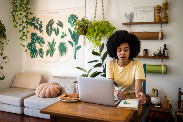 istock Latin woman with Afro hair using laptop at home 1492437343