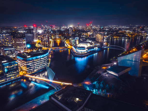 Drone view of Media city Salford quays at night, Manchester Drone view of Media city Salford quays at night, Manchester manchester england stock pictures, royalty-free photos & images