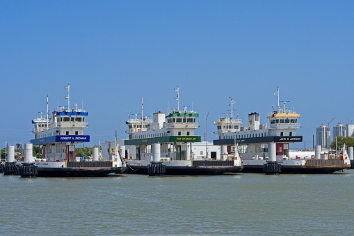 Galveston, TX - USA, April 26, 2023. Several car and passenger ferries lined up at Galveston harbor ready to transport tourists to historic Galveston island.