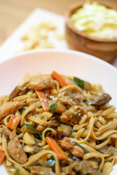 istock Rice noodles served with vegetables and meat in white bowl. 1492442375