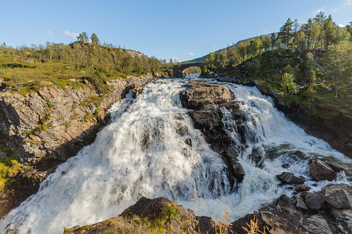 Scenic view of powerful  waterfall  in mountains in Norway