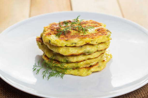 istock Stack of zucchini pancakes on white plate. Green vegetarian fritters. 1492456611