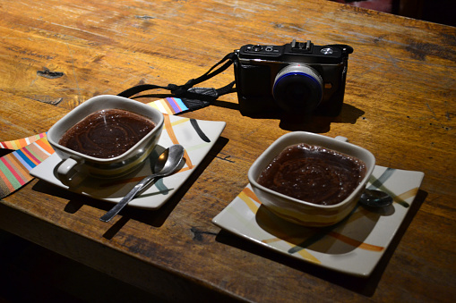 Hot chocolate and camera on a wooden table cozy