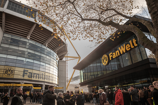 Picture of a crowd of supporters getting ready to enter the Signal Iduna Park stadium in Dortmund. Westfalenstadion is a football stadium in Dortmund, North Rhine-Westphalia, Germany, which is the home of Borussia Dortmund. Officially called Signal Iduna Park for sponsorship reasons and BVB Stadion Dortmund in UEFA competitions, the name derives from the former Prussian province of Westphalia.