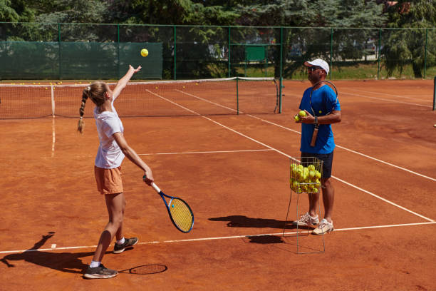 uma tenista profissional e seu treinador treinando em um dia ensolarado na quadra de tênis. treinamento e preparação de um tenista profissional - tennis coach serving playing - fotografias e filmes do acervo