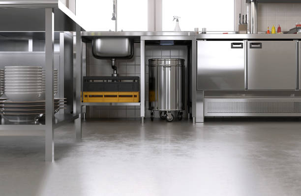 New, clean gray concrete resin vinyl floor in commercial, professional bakery kitchen, stainless steel cabinet, sink, trash bin, machine, equipment stock photo