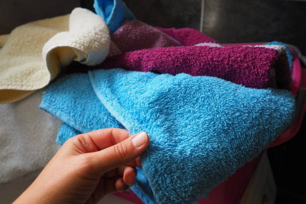 istock A woman's hand is feeling a cotton colored towel from a basket with dirty laundry. Laundry sorting and washing. Laundry room or bathroom. Housekeeping. Pink and blue terry towels. 1492463408