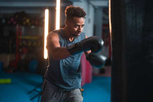 istock Mixed Race Male Professional Boxer Exercising With A Punching Bag 1492469640