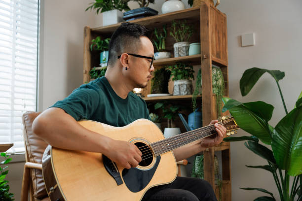 istock Middle aged man playing guitar at home 1492469868