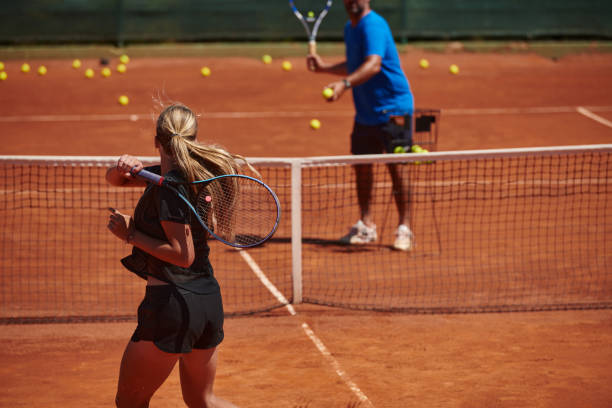 profesjonalna tenisistka i jej trener trenujący w słoneczny dzień na korcie tenisowym. trening i przygotowanie zawodowego tenisisty - tennis court sports training tennis net zdjęcia i obrazy z banku zdjęć