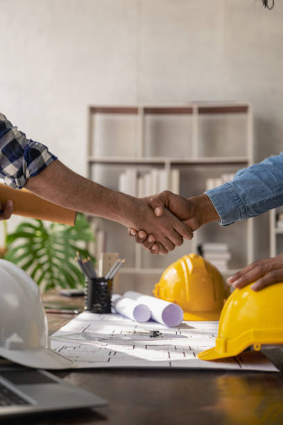 Professional Asian male engineer shaking hands with male architect after meeting to build modern building. Professional team in industry and concept of engineers. stock photo