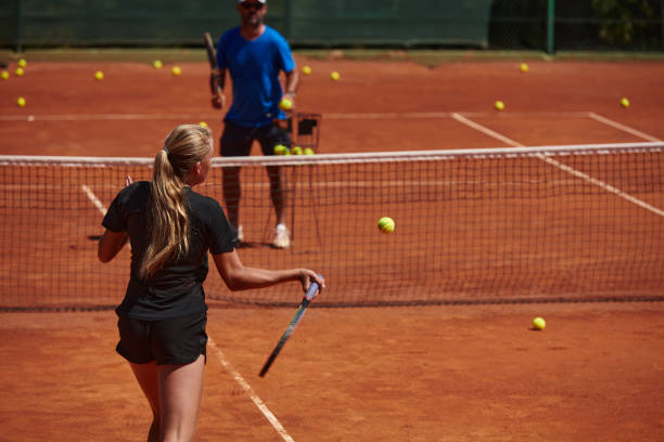 profesjonalna tenisistka i jej trener trenujący w słoneczny dzień na korcie tenisowym. trening i przygotowanie zawodowego tenisisty - tennis court sports training tennis net zdjęcia i obrazy z banku zdjęć