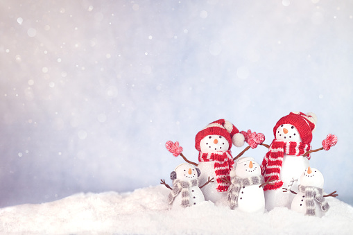 Happy snowman family cheering. Christmas card with copy space