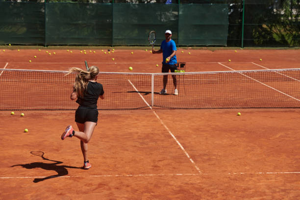 profesjonalna tenisistka i jej trener trenujący w słoneczny dzień na korcie tenisowym. trening i przygotowanie zawodowego tenisisty - tennis court sports training tennis net zdjęcia i obrazy z banku zdjęć