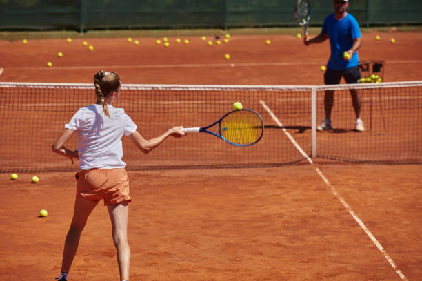 profesjonalna tenisistka i jej trener trenujący w słoneczny dzień na korcie tenisowym. trening i przygotowanie zawodowego tenisisty - tennis court sports training tennis net zdjęcia i obrazy z banku zdjęć