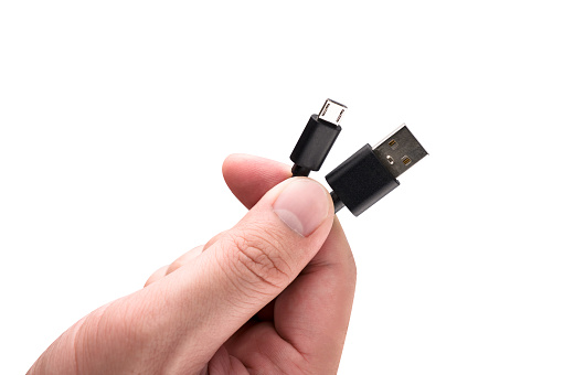 Hand holding USB cable isolated on white background.