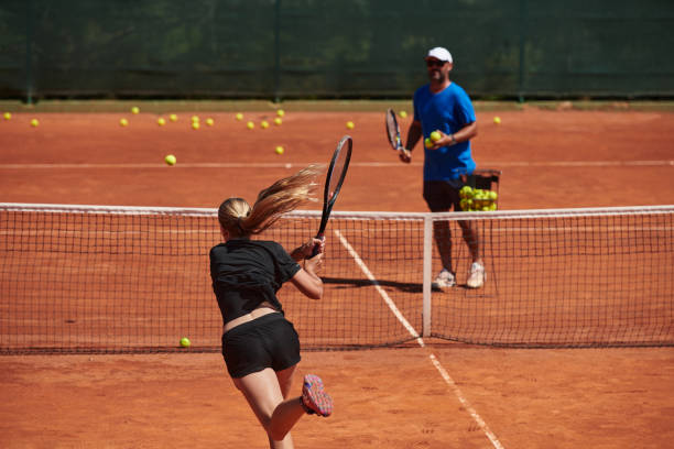 profesjonalna tenisistka i jej trener trenujący w słoneczny dzień na korcie tenisowym. trening i przygotowanie zawodowego tenisisty - tennis court sports training tennis net zdjęcia i obrazy z banku zdjęć