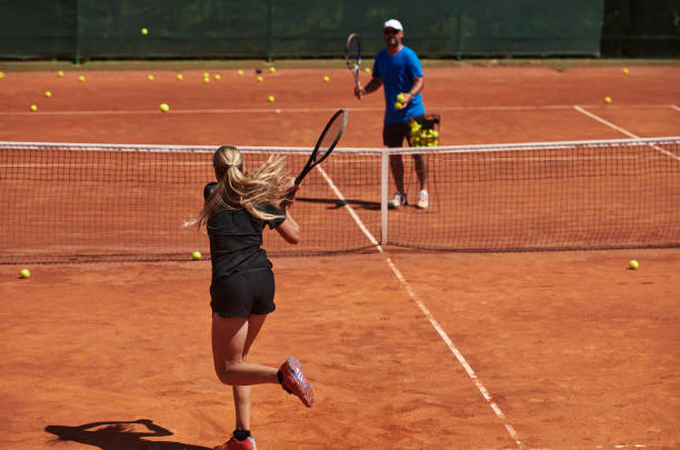 profesjonalna tenisistka i jej trener trenujący w słoneczny dzień na korcie tenisowym. trening i przygotowanie zawodowego tenisisty - tennis court sports training tennis net zdjęcia i obrazy z banku zdjęć