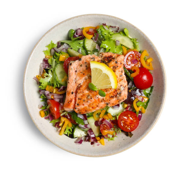 istock Bowl with tasty salmon, lemon and mixed vegetables on white background, top view 1492483240