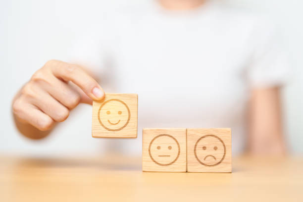 istock Hand choosing smile face from Emotion block for customer review, good experience, positive feedback, satisfaction, survey, evaluation, assessment, mood and world mental health day concept 1492483268