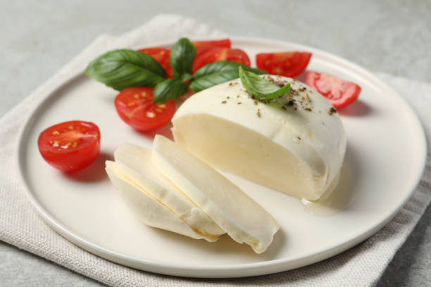 istock Delicious mozzarella with tomatoes and basil leaves on table, closeup 1492483449