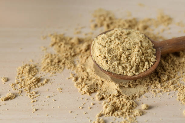 istock Spoon with aromatic mustard powder on wooden table, closeup. Space for text 1492484772
